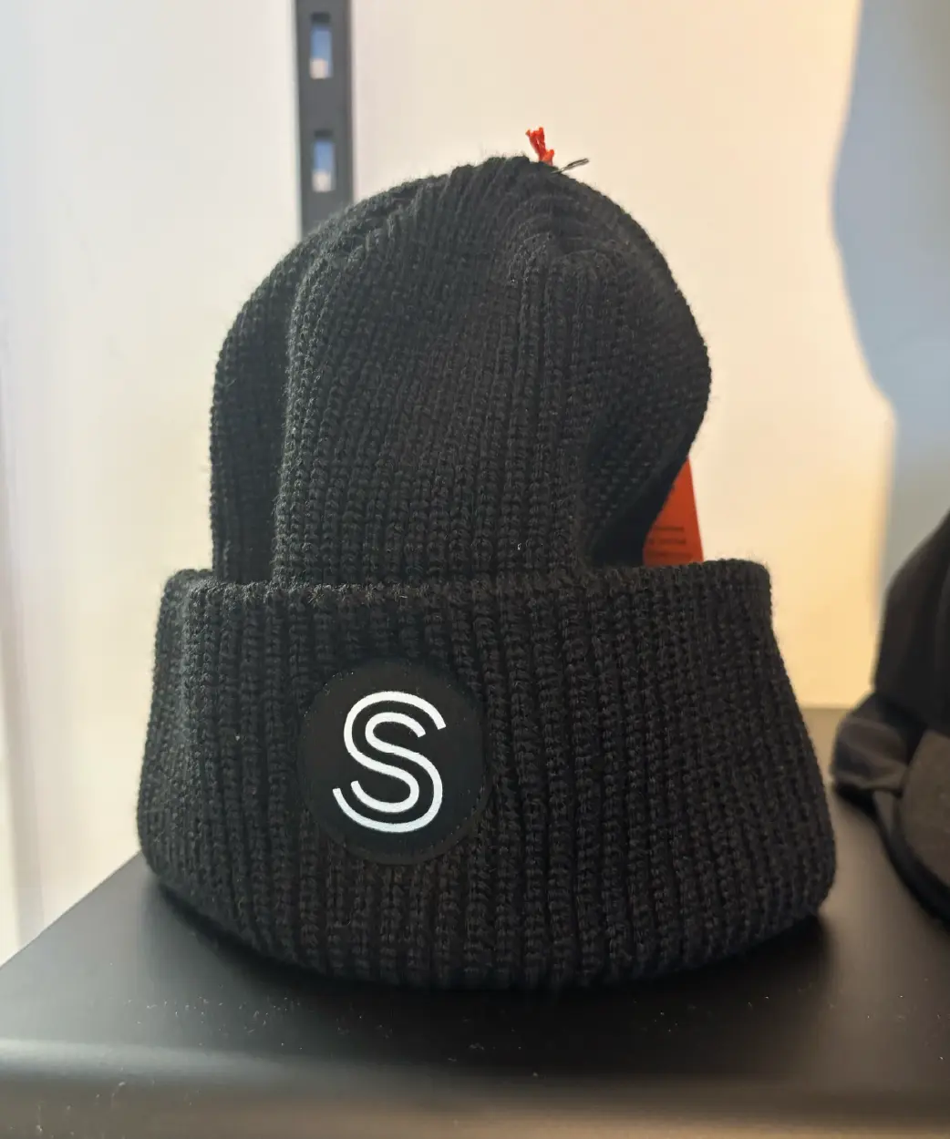 une tuque noire avec le logo de Shawbridge